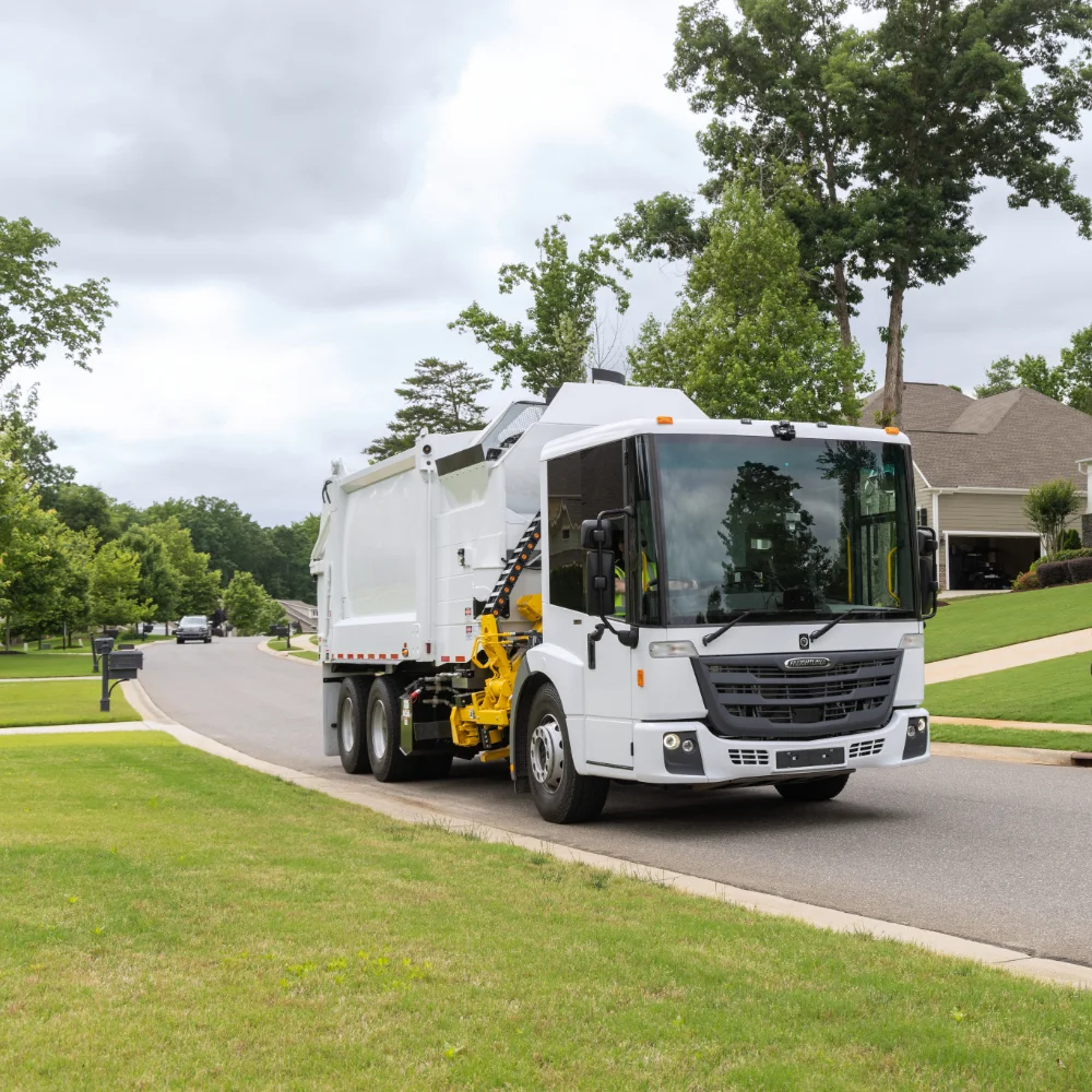 Close-up of Freightliner garbage truck front and cab on a suburban street